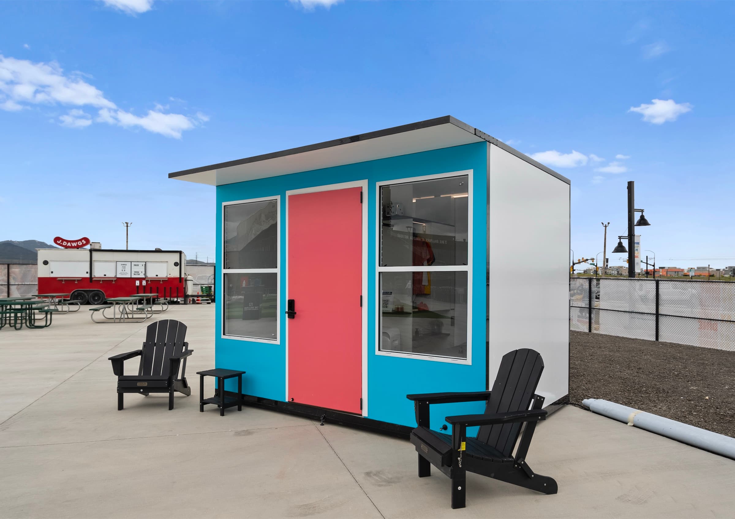 A deployed Sanctuary Sleep unit on a paved site with two chairs outside